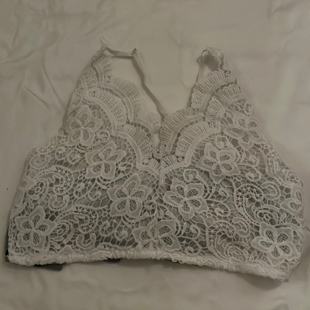 Adorable crop top! Great condition. White lace in front, blue floral tie in back